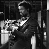 a black and white photo of a man playing an acoustic guitar